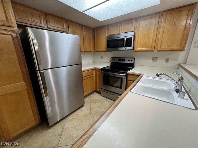 8940 Antioch Way, Las Vegas, NV 89117 - kitchen featuring appliances with stainless steel finishes, a sink, light tile patterned floors, light countertops, and brown cabinets