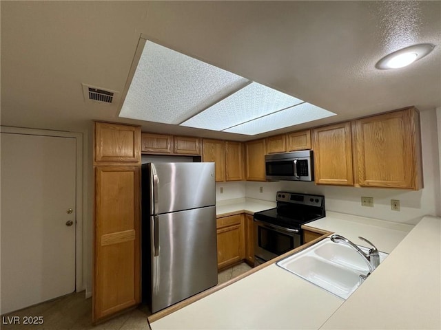 8940 Antioch Way, Las Vegas, NV 89117 - kitchen with stainless steel appliances, a sink, brown cabinetry, and light countertops