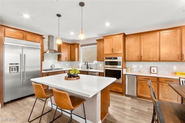 12430 Foxtail Run Ave, Las Vegas, NV 89138 - kitchen with stainless steel appliances, wall chimney exhaust hood, a sink, light wood-type flooring, and recessed lighting