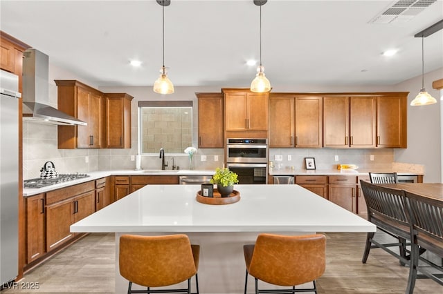 12430 Foxtail Run Ave, Las Vegas, NV 89138 - kitchen with wall chimney range hood, appliances with stainless steel finishes, brown cabinets, a sink, and recessed lighting