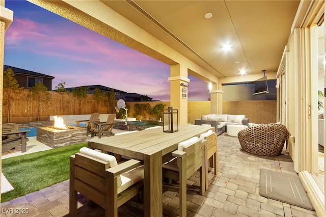 12430 Foxtail Run Ave, Las Vegas, NV 89138 - patio terrace at dusk with a patio, an outdoor living space with a fire pit, and outdoor dining area