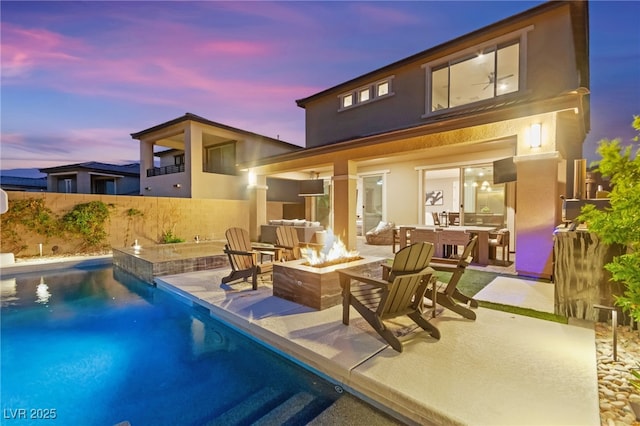 12430 Foxtail Run Ave, Las Vegas, NV 89138 - rear view of house featuring an outdoor fire pit, stucco siding, and a patio