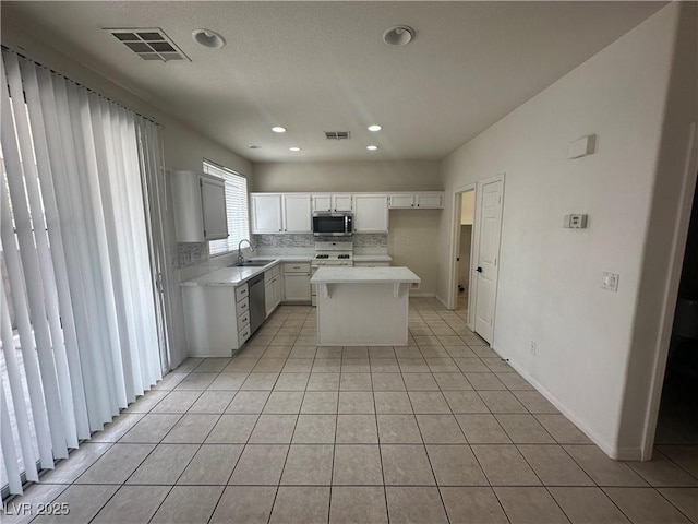 8215 Shell Beach Ct, Las Vegas, NV 89117 - kitchen featuring appliances with stainless steel finishes, a sink, light tile patterned flooring, light countertops, and decorative backsplash