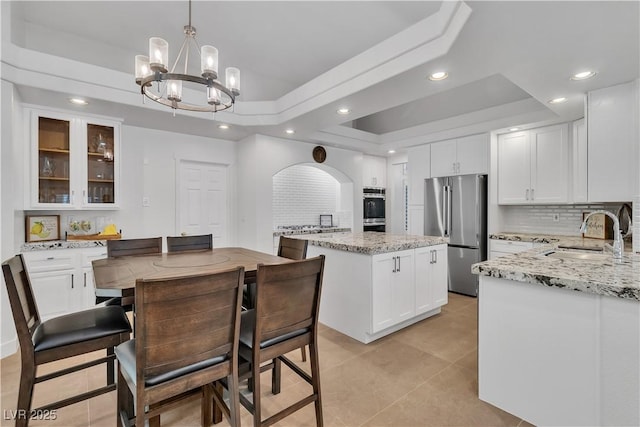 4196 Balmoral Castle Ct, Las Vegas, NV 89141 - kitchen featuring stainless steel appliances, a sink, tasteful backsplash, a kitchen island, and a raised ceiling