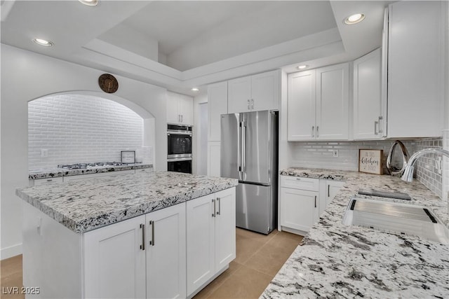4196 Balmoral Castle Ct, Las Vegas, NV 89141 - kitchen featuring stainless steel appliances, a sink, backsplash, light stone countertops, and recessed lighting