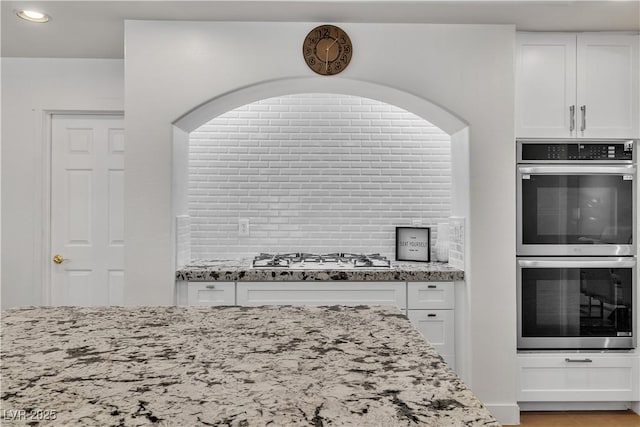 4196 Balmoral Castle Ct, Las Vegas, NV 89141 - kitchen with double oven, gas cooktop, light stone countertops, white cabinetry, and recessed lighting