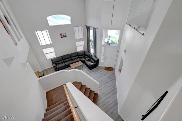 8333 Valley Stream Ave, Las Vegas, NV 89131 - staircase with a high ceiling, a chandelier, and wood finished floors