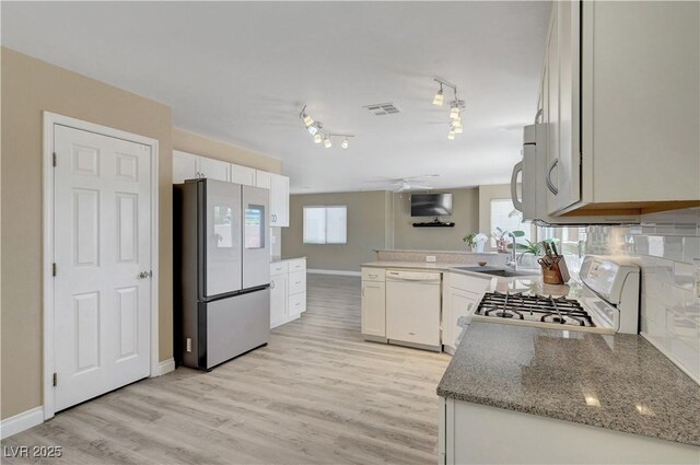 8333 Valley Stream Ave, Las Vegas, NV 89131 - kitchen featuring white appliances, a sink, light wood finished floors, white cabinetry, and a peninsula