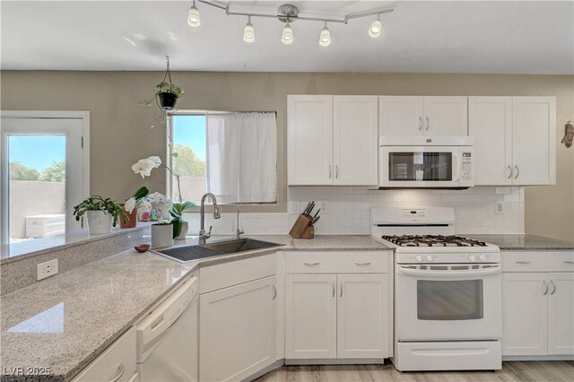 8333 Valley Stream Ave, Las Vegas, NV 89131 - kitchen featuring white appliances, a sink, healthy amount of natural light, and white cabinetry