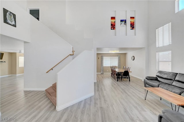 8333 Valley Stream Ave, Las Vegas, NV 89131 - living area with a high ceiling, light wood-style flooring, stairway, and baseboards