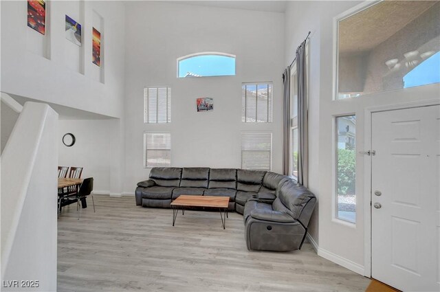 8333 Valley Stream Ave, Las Vegas, NV 89131 - living room with a high ceiling, plenty of natural light, wood finished floors, and baseboards