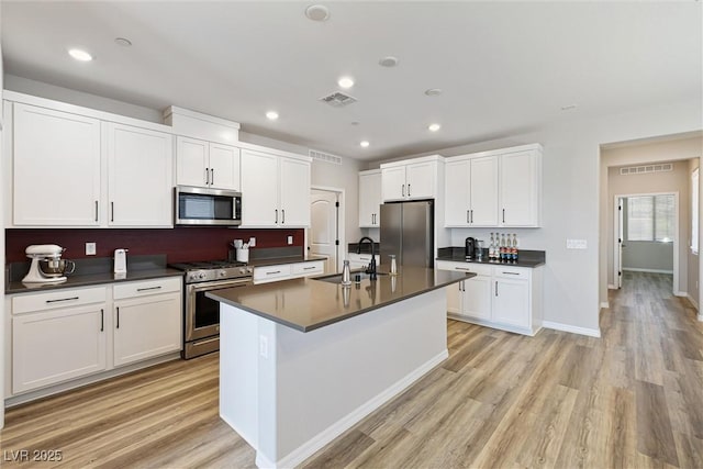 171 Palm Fox Ct, Henderson, NV 89011 - kitchen featuring appliances with stainless steel finishes, a sink, dark countertops, light wood-style floors, and recessed lighting