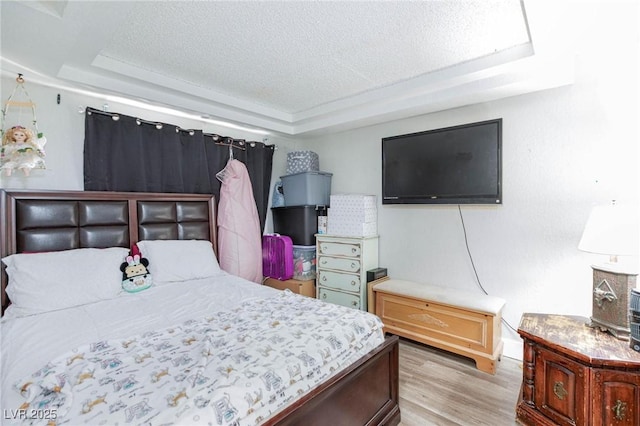 45 N Lamb Blvd, Las Vegas, NV 89110 - bedroom featuring a tray ceiling, light wood-style flooring, a textured ceiling, and baseboards