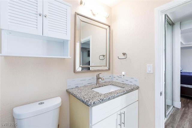 45 N Lamb Blvd, Las Vegas, NV 89110 - bathroom featuring vanity, toilet, wood finished floors, and backsplash