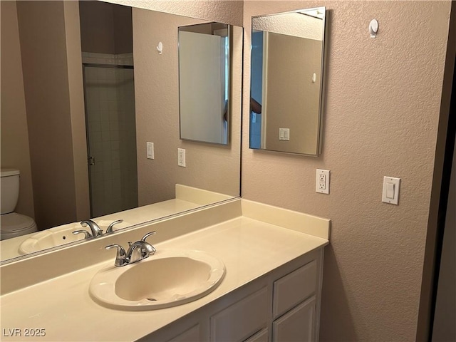 6865 Tamarus St Unit 202, Las Vegas, NV 89119 - bathroom featuring a textured wall, toilet, and vanity