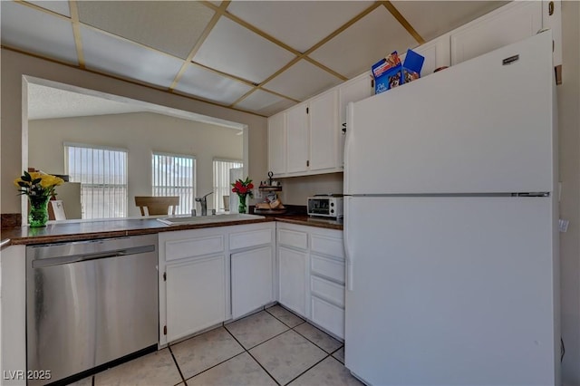 4445 Peterson Dr, Las Vegas, NV 89103 - kitchen featuring freestanding refrigerator, dishwasher, a sink, dark countertops, and white cabinets