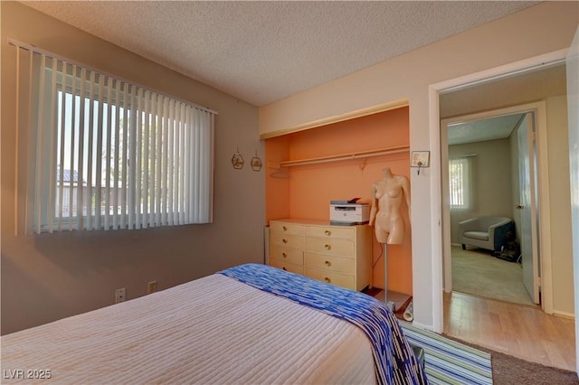 4445 Peterson Dr, Las Vegas, NV 89103 - carpeted bedroom featuring a closet, a textured ceiling, and wood finished floors