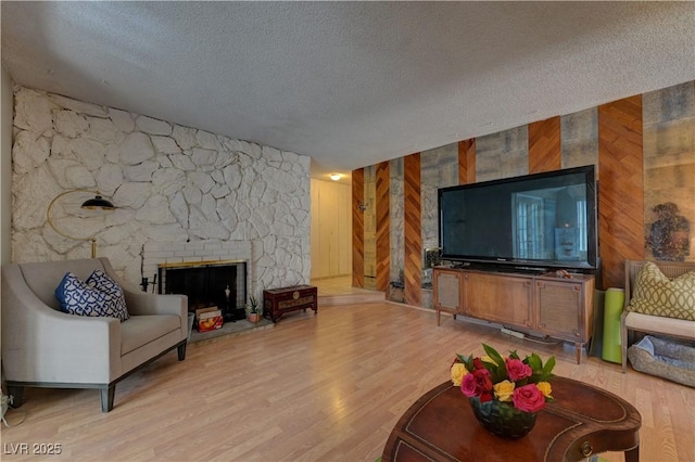 4445 Peterson Dr, Las Vegas, NV 89103 - living area with a textured ceiling, wooden walls, wood finished floors, and a stone fireplace