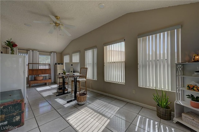 4445 Peterson Dr, Las Vegas, NV 89103 - tiled dining area featuring vaulted ceiling, plenty of natural light, ceiling fan, and a textured ceiling