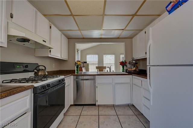 4445 Peterson Dr, Las Vegas, NV 89103 - kitchen with freestanding refrigerator, gas stove, stainless steel dishwasher, dark countertops, and a drop ceiling