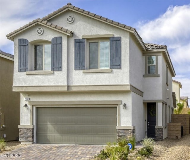 7061 Tilligerry St, North Las Vegas, NV 89084 - mediterranean / spanish house featuring stone siding, stucco siding, a garage, and driveway