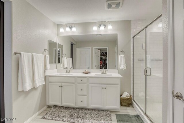 7061 Tilligerry St, North Las Vegas, NV 89084 - full bathroom with a shower stall, double vanity, tile patterned floors, a spacious closet, and baseboards