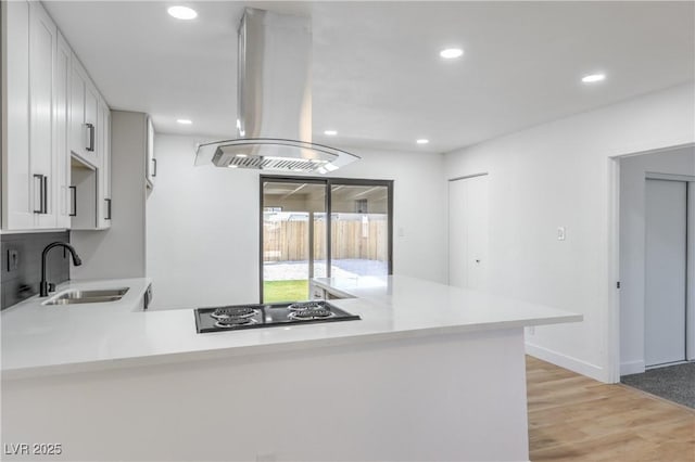 333 Rossmoyne Ave, North Las Vegas, NV 89030 - kitchen with a sink, island exhaust hood, black stovetop, light countertops, and recessed lighting