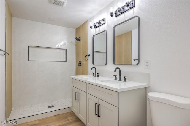 333 Rossmoyne Ave, North Las Vegas, NV 89030 - bathroom with tiled shower, toilet, double vanity, and wood finished floors