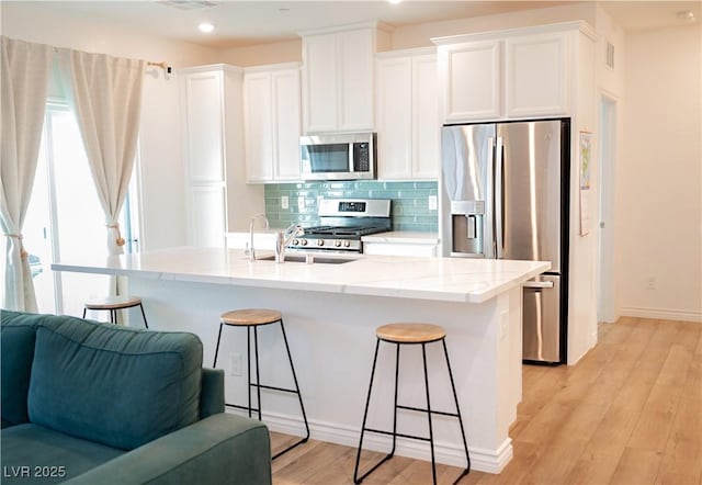 7342 N Decatur Blvd Unit 5, Las Vegas, NV 89131 - kitchen featuring stainless steel appliances, a breakfast bar area, tasteful backsplash, white cabinetry, and open floor plan