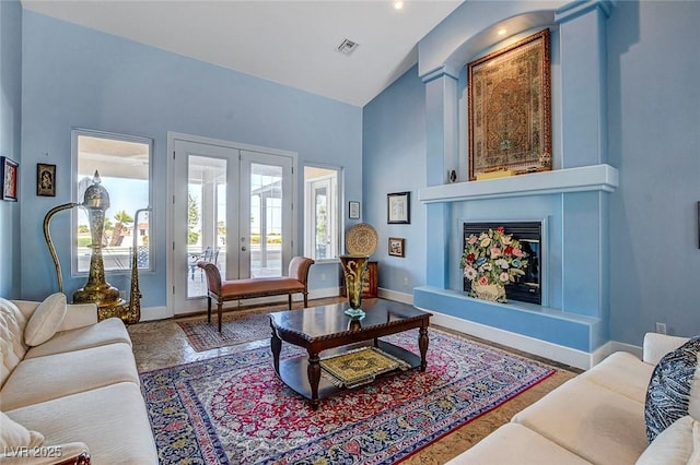 6230 Calm Brook Ct, Las Vegas, NV 89149 - living area with french doors, baseboards, a large fireplace, and high vaulted ceiling