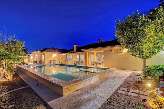 6230 Calm Brook Ct, Las Vegas, NV 89149 - pool at night featuring a patio and a pool with connected hot tub