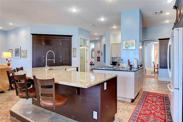 6230 Calm Brook Ct, Las Vegas, NV 89149 - kitchen with a sink, freestanding refrigerator, a spacious island, a breakfast bar area, and recessed lighting
