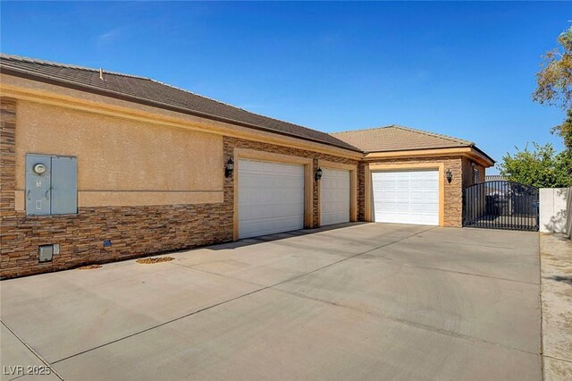 6230 Calm Brook Ct, Las Vegas, NV 89149 - view of home's exterior with driveway, a gate, an attached garage, stone siding, and stucco siding