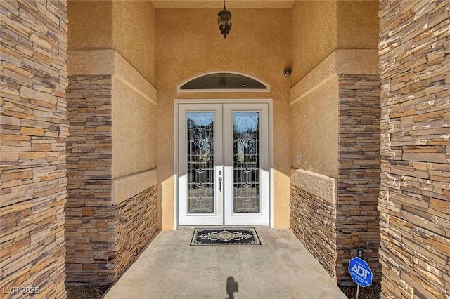 6230 Calm Brook Ct, Las Vegas, NV 89149 - view of exterior entry featuring french doors, stucco siding, and stone siding
