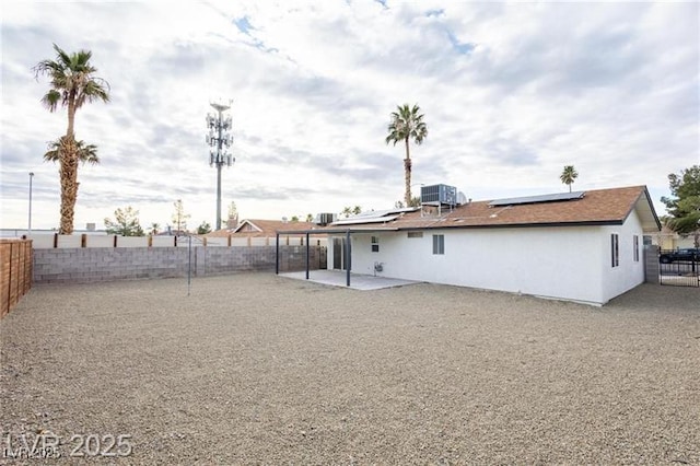6170 W University Ave, Las Vegas, NV 89103 - back of property featuring a patio, roof mounted solar panels, a fenced backyard, and stucco siding