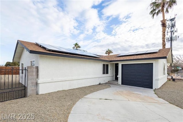 6170 W University Ave, Las Vegas, NV 89103 - ranch-style house featuring a garage, driveway, roof mounted solar panels, a gate, and stucco siding