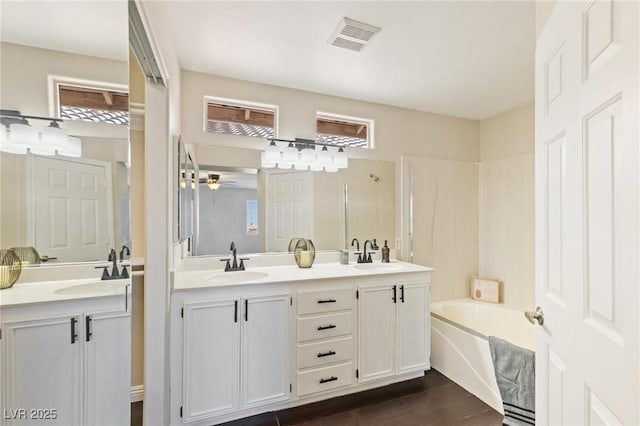 8507 Titania Ct, Las Vegas, NV 89147 - bathroom featuring double vanity, a ceiling fan, a garden tub, and wood finished floors