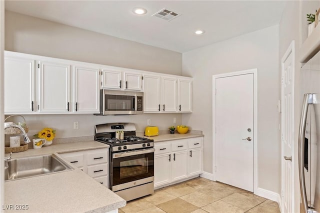 8507 Titania Ct, Las Vegas, NV 89147 - kitchen with appliances with stainless steel finishes, a sink, white cabinets, light countertops, and recessed lighting