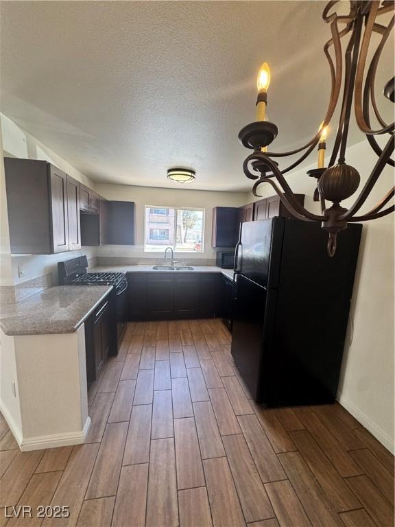 1505 Frank Aved St Unit 101, Las Vegas, NV 89110 - kitchen with black appliances, light wood-style flooring, a textured ceiling, and light stone countertops