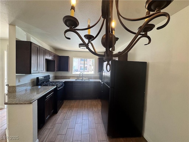 1505 Frank Aved St Unit 101, Las Vegas, NV 89110 - kitchen with black appliances, wood finished floors, a textured ceiling, dark brown cabinets, and light stone counters