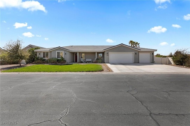 1395 Logandale Dr, Logandale, NV 89021 - ranch-style house with concrete driveway, an attached garage, and stucco siding