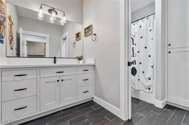 1395 Logandale Dr, Logandale, NV 89021 - bathroom featuring wood tiled floors, baseboards, vanity, and shower / tub combo