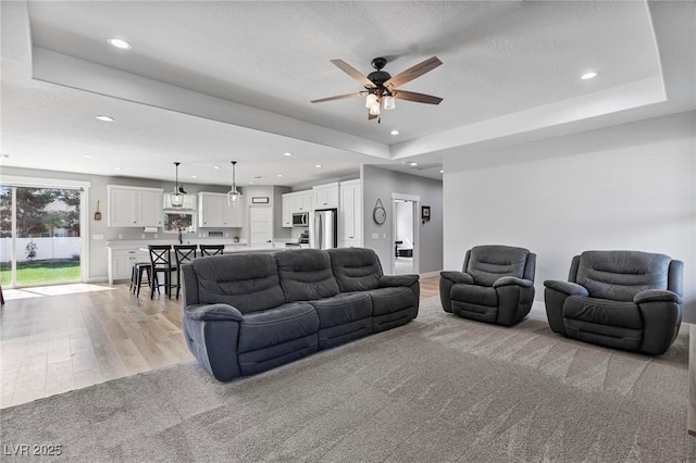 1395 Logandale Dr, Logandale, NV 89021 - living area featuring light colored carpet, recessed lighting, a raised ceiling, ceiling fan, and light wood-type flooring
