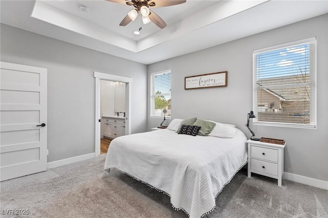 1395 Logandale Dr, Logandale, NV 89021 - bedroom featuring baseboards, carpet flooring, a tray ceiling, and connected bathroom