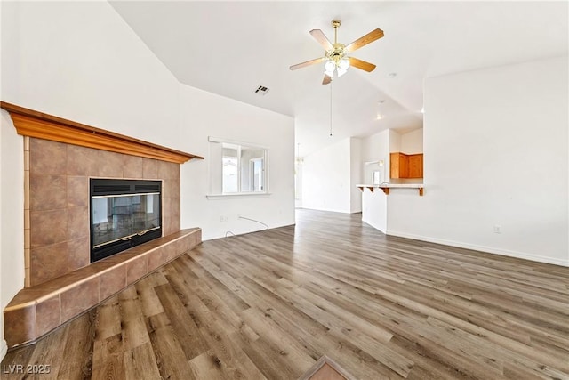 654 Mazelle Ln, Pahrump, NV 89060 - unfurnished living room featuring vaulted ceiling, wood finished floors, a ceiling fan, and a fireplace