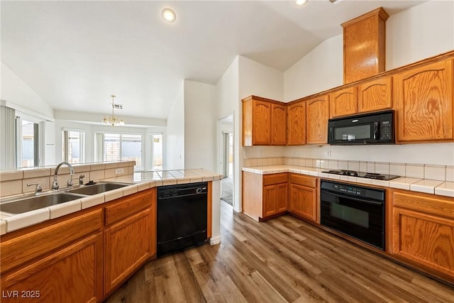 654 Mazelle Ln, Pahrump, NV 89060 - kitchen with black appliances, lofted ceiling, a sink, dark wood-style floors, and a chandelier