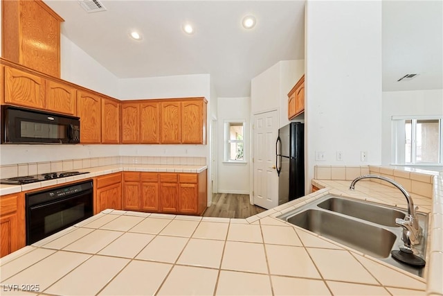 654 Mazelle Ln, Pahrump, NV 89060 - kitchen featuring black appliances, tile counters, a sink, brown cabinets, and recessed lighting