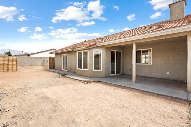 654 Mazelle Ln, Pahrump, NV 89060 - rear view of house with stucco siding, a tile roof, a patio, and a chimney
