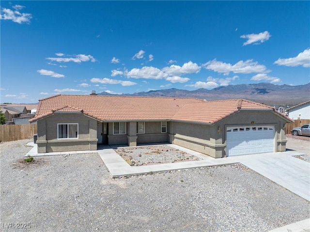 654 Mazelle Ln, Pahrump, NV 89060 - ranch-style home featuring a tiled roof, stucco siding, an attached garage, and a mountain view
