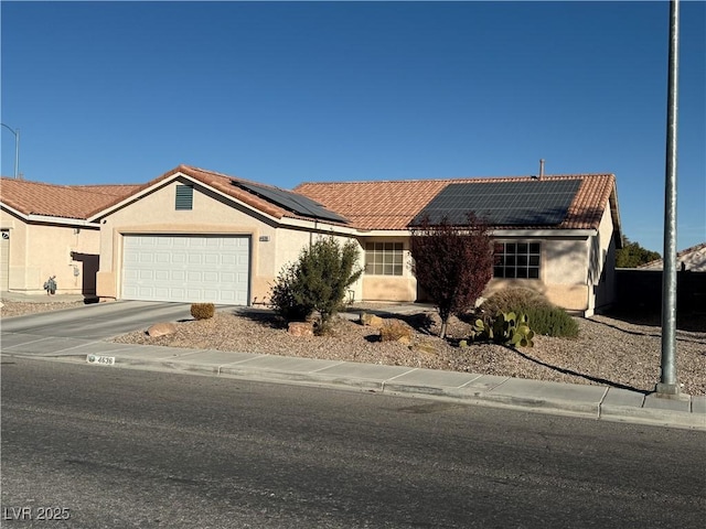 4636 Ferrell St, North Las Vegas, NV 89031 - ranch-style house with a tiled roof, solar panels, an attached garage, and stucco siding